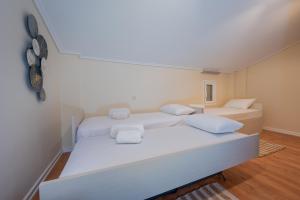 a white bedroom with two beds with white pillows at Nikole's Villas Cozy 80m2 in Tiros