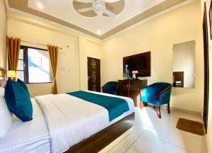 a hotel room with a bed and a chair and a television at Tapovan New Residency - 5 minutes walk to Laxman jhula in Rishīkesh +59 photos