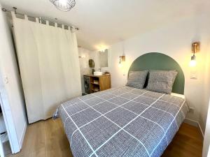 Schlafzimmer mit einem Bett mit einer grünen und weißen Bettdecke in der Unterkunft Suite ~ Romance Estivale ~ à 15 min de Lyon in Miribel