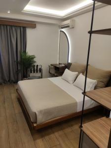 1 dormitorio con 1 cama y 1 habitación con espejo en Adonis City Hotel en Patras