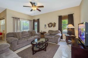 een woonkamer met een bank en een tv bij Dahlia Reserve at Ellis Exclusive Villas in Kissimmee