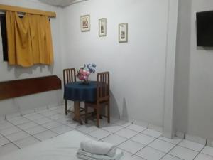 a room with a table and two chairs and a television at APARTHOTEL CENTRAL MACAPÁ in Macapá