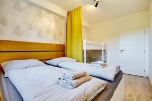 2 Betten in einem Zimmer mit Handtüchern darauf in der Unterkunft Klínovec Suite in Loučná pod Klínovcem