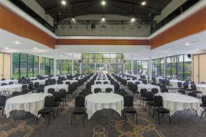 un salón de banquetes con mesas y sillas blancas en Four Points by Sheraton San Diego, en San Diego