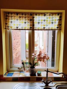 a kitchen window with a sink and a window shade at House - Alton Towers,Peak District,Wildlife Park in Leek