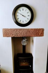 a clock hanging on a wall above a fireplace at House - Alton Towers,Peak District,Wildlife Park in Leek