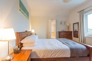 een slaapkamer met een bed en een tafel met een lamp bij Character property perfect for families in Ryde