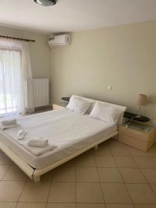 1 dormitorio con 1 cama grande con sábanas y almohadas blancas en Complex Summer Memories en Keramotí