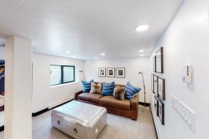 a living room with a brown couch and blue pillows at Beaver Creeks Meadows Ski-In Ski-Out in Beaver Creek