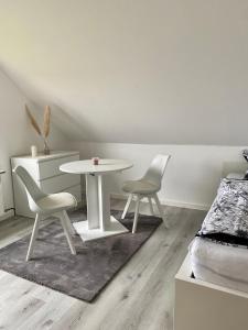 uma sala de jantar com uma mesa e duas cadeiras em 2- Zimmer Wohnung em Lehrte