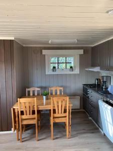 貝圖斯托的住宿－Liten og koselig hytte，厨房配有木桌和椅子