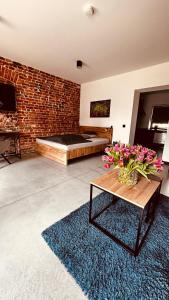 una habitación con una cama y una mesa con flores. en Apartamenty Gliwice Staromiejska 65, en Gliwice