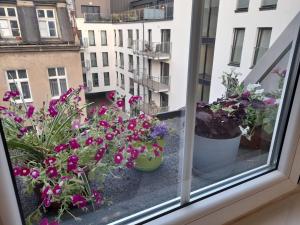 uma janela com flores em vasos numa varanda em Apartament Garbary em Poznań