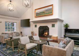 a living room with couches and tables and a fireplace at Half Moon Bay Lodge in Half Moon Bay