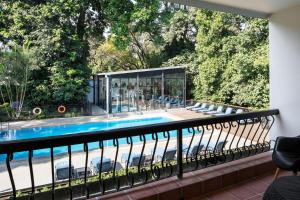 a balcony with a swimming pool and chairs at Four Points by Sheraton Arusha, The Arusha Hotel in Arusha