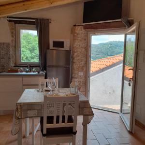 een keuken met een tafel en een groot raam bij Cà di Pippo "Riccio" appartamento Loc Boragni Orco Feglino in Vezzi Portio