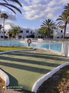 un parcours de golf en face d'une piscine dans l'établissement Alojamientos Playa Centro Corralejo 15, à Corralejo