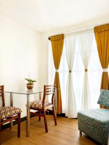 a dining room with a table and chairs and curtains at Casa Orquídea in Fusagasuga