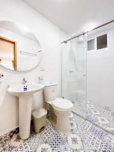 a bathroom with a toilet and a sink and a shower at Casa Orquídea in Fusagasuga