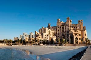 a large building on the beach next to the ocean at Sheraton Sharjah Beach Resort and Spa in Sharjah