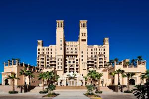 duży budynek z palmami przed nim w obiekcie Sheraton Sharjah Beach Resort and Spa w Szardży