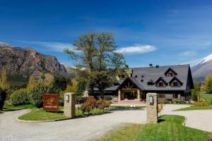 une maison dans les montagnes avec une allée dans l'établissement Arelauquen Lodge, a Tribute Portfolio Hotel, à San Carlos de Bariloche