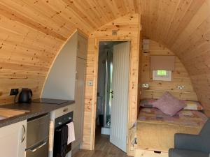 1 dormitorio pequeño en una cabaña de madera con 1 cama pequeña en Waterpump Pod for 2 adults with ensuite in the Suffolk Countryside, en Badingham