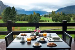 a table with food on it with a view of mountains at Arelauquen Lodge, a Tribute Portfolio Hotel in San Carlos de Bariloche