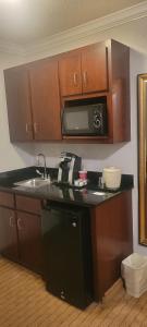 a kitchen with a sink and a microwave at The Arc Hotel in Fort Smith