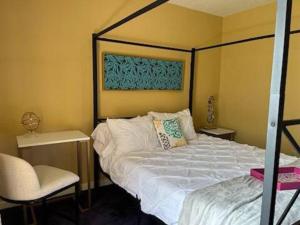 a bedroom with a bed and a chair in it at A Bliss of Color Townhouse in Jackson