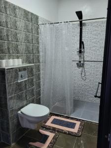 La salle de bains est pourvue d'une douche, de toilettes et d'un rideau de douche. dans l'établissement Villa avec piscine marrakech, à Marrakech