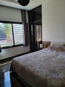 ein Schlafzimmer mit einem großen Bett und zwei Fenstern in der Unterkunft Villa avec piscine marrakech in Marrakesch