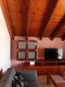a living room with a couch and a flat screen tv at Apartment Batolios in Agios Georgios