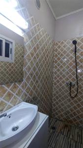 y baño con lavabo blanco y ducha. en AS Guest House, en Libreville