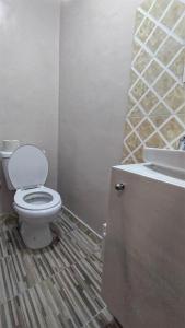 uma casa de banho com um WC e um lavatório em AS Guest House em Libreville
