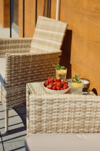 a table with a bowl of strawberries and drinks on it at Błękitna Laguna in Zator