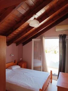 a bedroom with a large bed and a window at Apartment Batolios in Agios Georgios