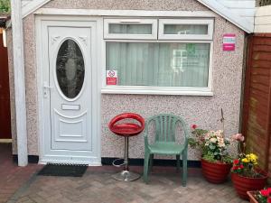 a door and a chair in front of a house at Harman Suites Self-Catering Apartments Free WIFI & Parking in Leeds