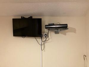 a flat screen tv hanging on a wall at Harman Suites Self-Catering Apartments Free WIFI & Parking in Leeds