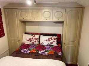 a bed in a small room with flowers on it at Harman Suites Self-Catering Apartments Free WIFI & Parking in Leeds