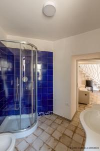 een blauw betegelde badkamer met een douche en een wastafel bij Casa Mimina in Ischia