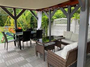 a patio with a couch and a table and chairs at Willa Perła Morza in Władysławowo