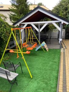 a playground on a green lawn with a pavilion at Willa Perła Morza in Władysławowo