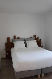 un grande letto bianco con lenzuola e cuscini bianchi di Appt 4 pers avec parking privé gratuit Le Touquet a Le Touquet-Paris-Plage