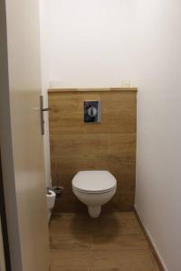 a bathroom with a white toilet and a wooden wall at Appt 4 pers avec parking privé gratuit Le Touquet in Le Touquet-Paris-Plage