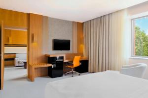 Four Points by Sheraton Kecskemét Hotel és Konferenciaközpont في كيسكيميت: غرفة في الفندق بها سرير ومكتب وتلفزيون