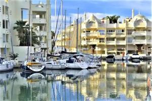 a group of boats docked in a marina with buildings at New confort Benalmádena in Benalmádena