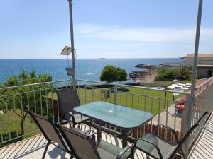 a balcony with a table and chairs and the ocean at Apartment Batolios in Agios Georgios