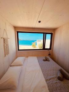 a room with two beds in a room with a window at MODERN BEACH VILLAS - Buqez Camp resort in Drage