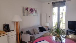 sala de estar con sofá y mesa en Maison de Line en LʼÎle-dʼOlonne